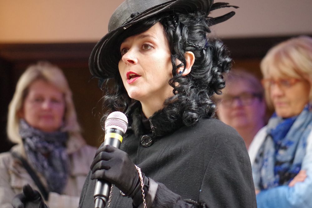 In Schwarz gekleidete Frau hält einen Vortrag